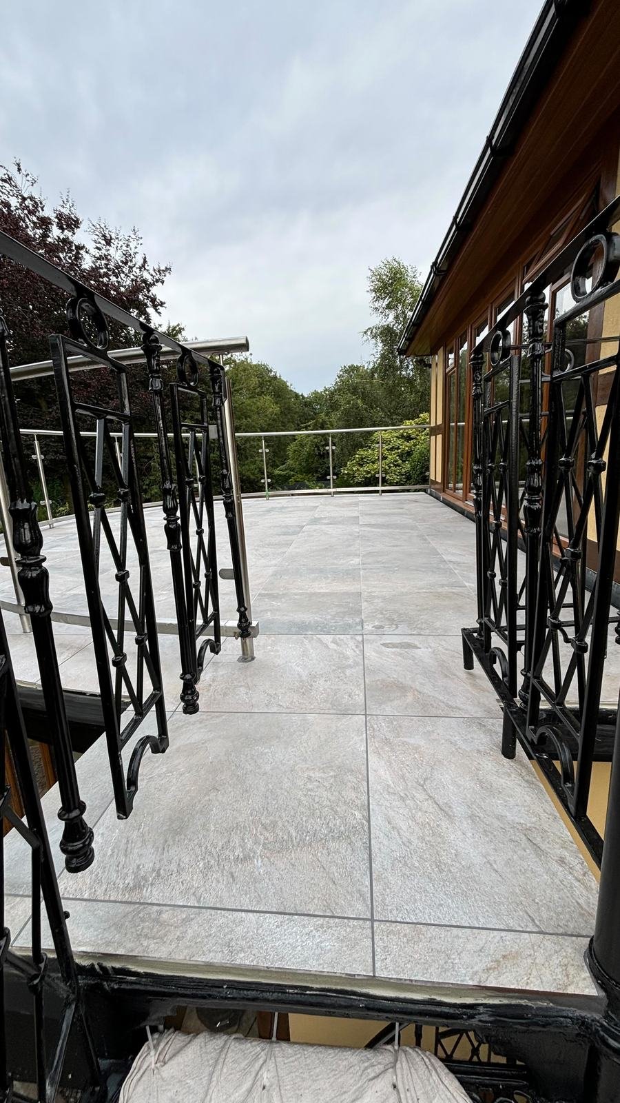 Balcony re-tiled in pale porcelain with black railings
