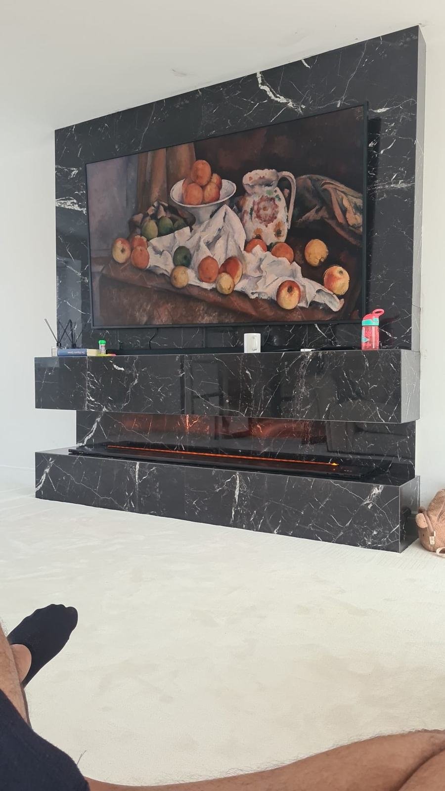 Black marble-effect feature wall with mitred edges around a fireplace