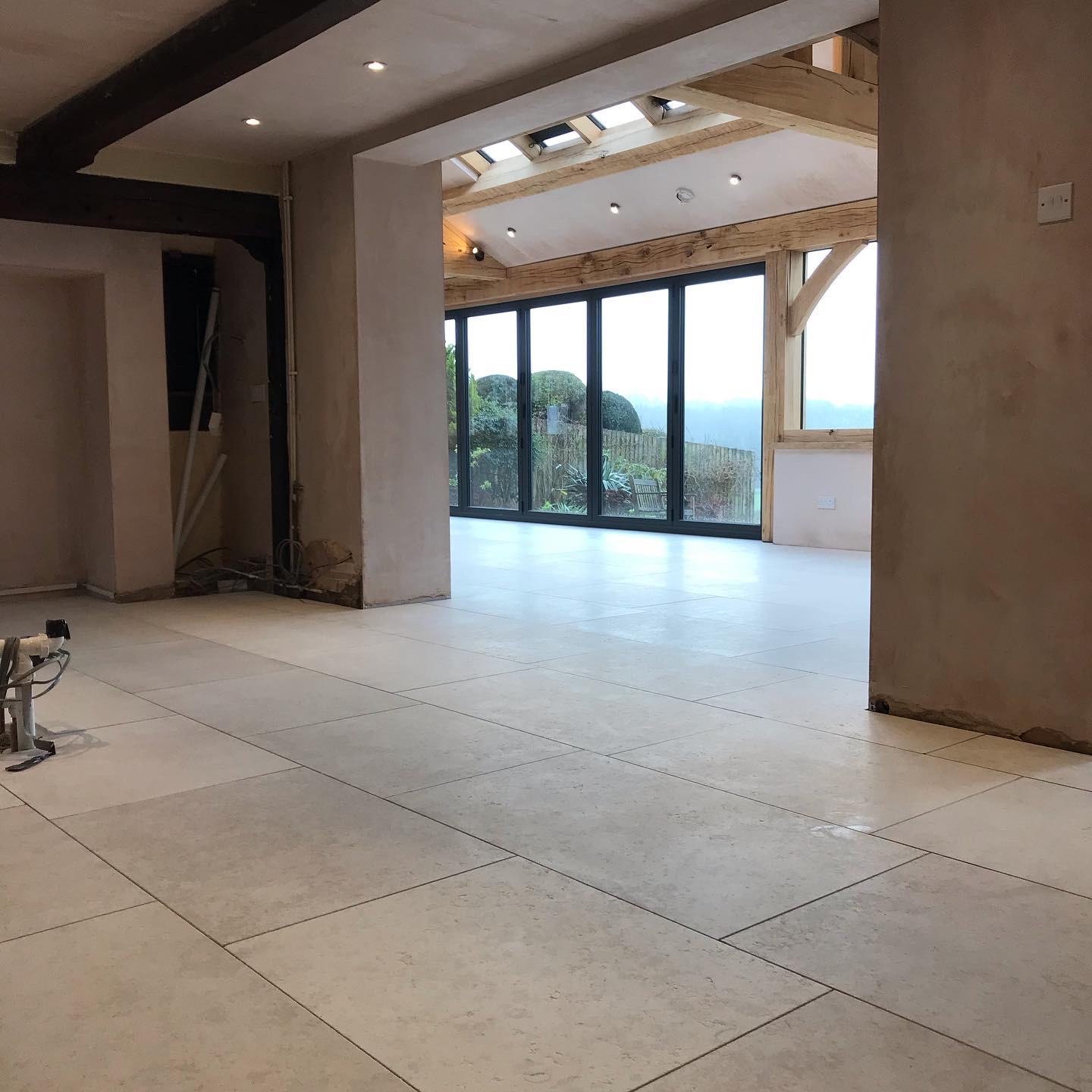 Open-plan extension floored in large pale porcelain tiles