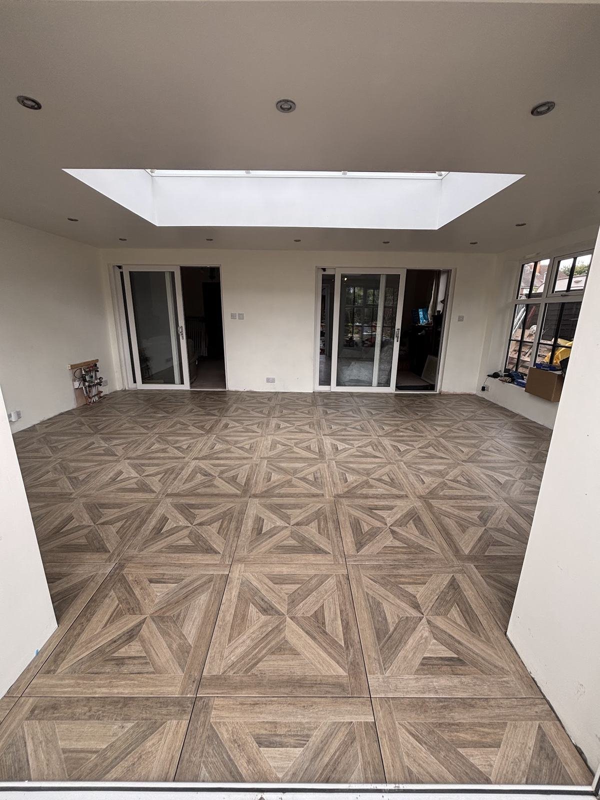 New extension floored in parquet-pattern wood-effect porcelain under a roof lantern