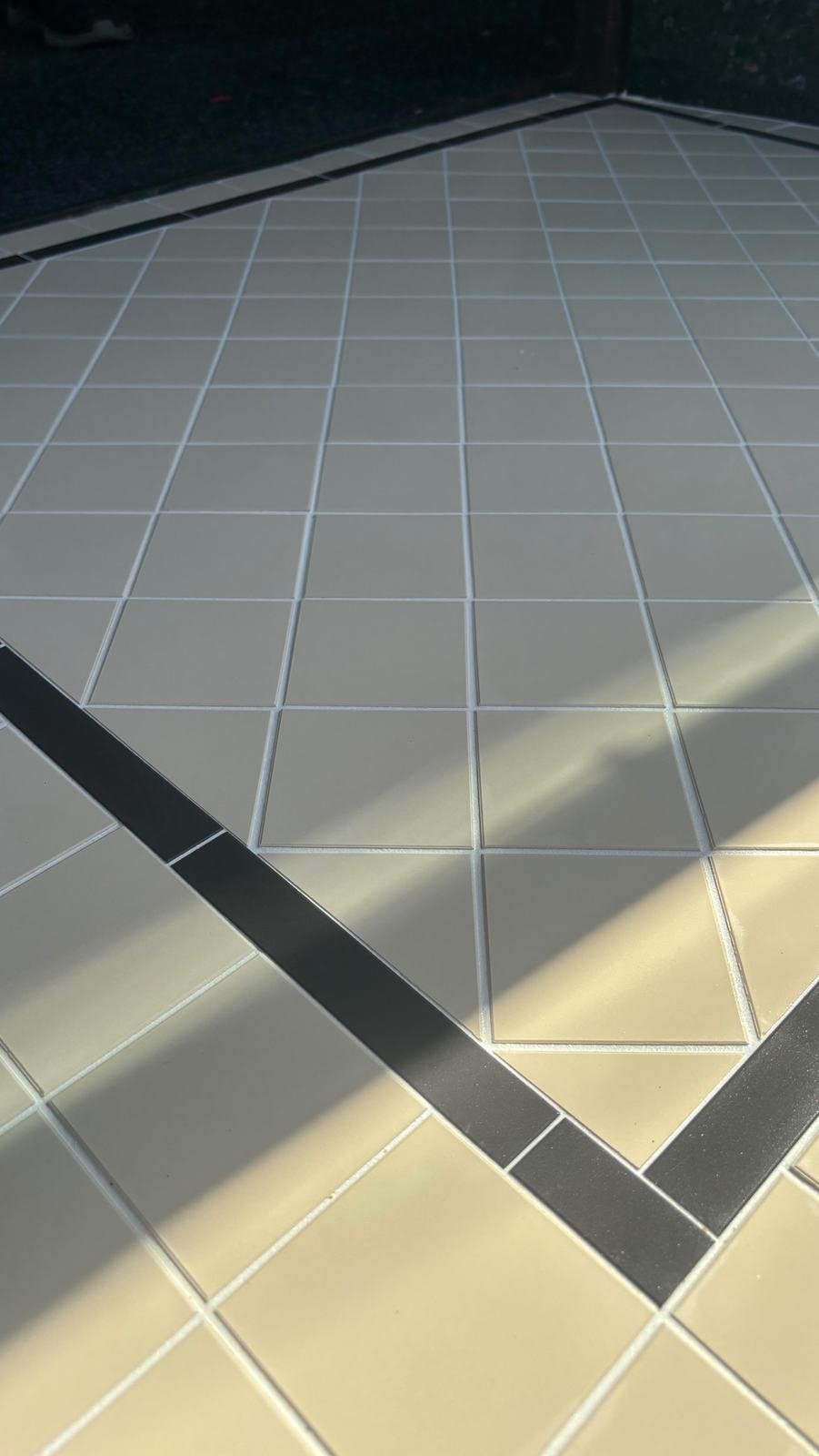 Shop entrance tiled in pale squares with a dark diagonal band