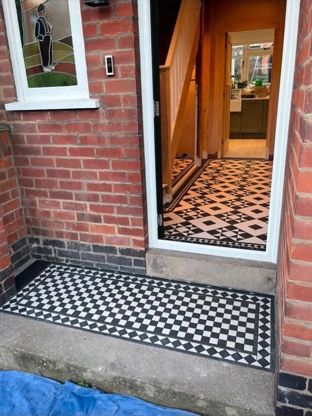 Victorian-style black and white front path leading to a porch