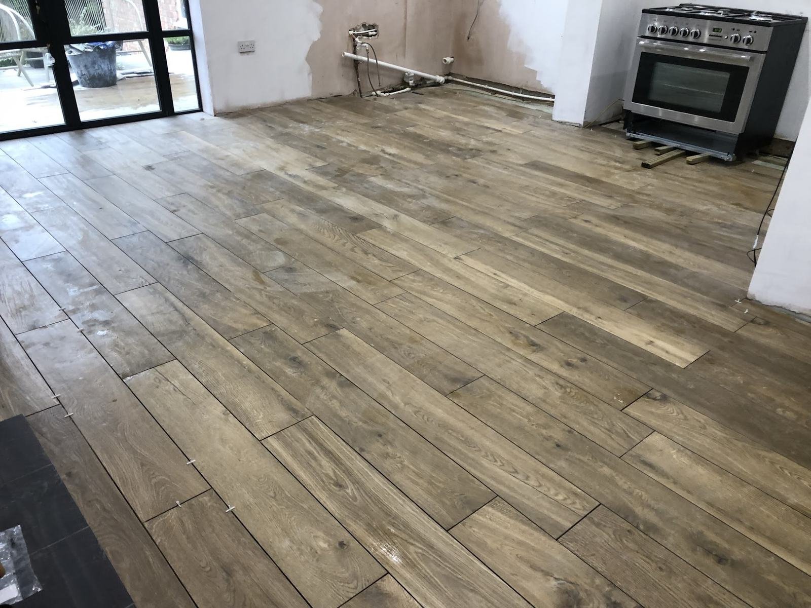 Wood-effect porcelain planks across a kitchen floor